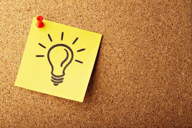A light bulb that represents an idea in front of a board.